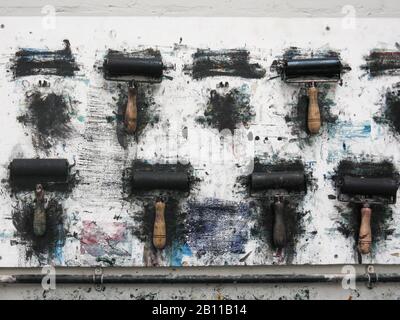 Rouleaux d'impression accrochés sur un mur d'art studio dans l'atelier désordonné Banque D'Images