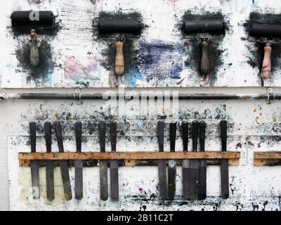 Rouleaux d'impression accrochés sur un mur d'art studio dans l'atelier désordonné Banque D'Images