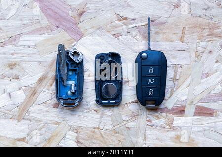 Télécommande cassée ou endommagée et nouvelle clé de véhicule sur fond en bois abstrait. Remplacement de la pile de la télécommande cassée ou endommagée de tout véhicule Banque D'Images