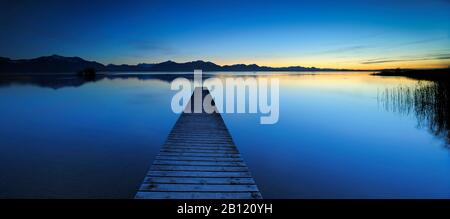 Après le coucher du soleil à Chiemsee, quai en bateau avec les Alpes de Chiemgau, Bavière, Allemagne Banque D'Images