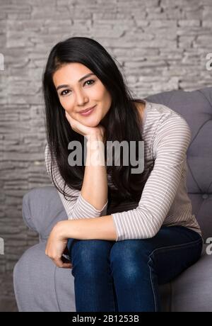 Femme assise sur un fauteuil Banque D'Images