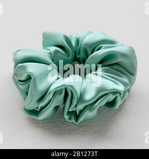 Soie turquoise Scrochy isolé sur fond blanc. Outil De Coiffure Plat Pour Cheveux Élastiques Colorés, Bandeau À Cheveux Bouloches Scrochie Banque D'Images