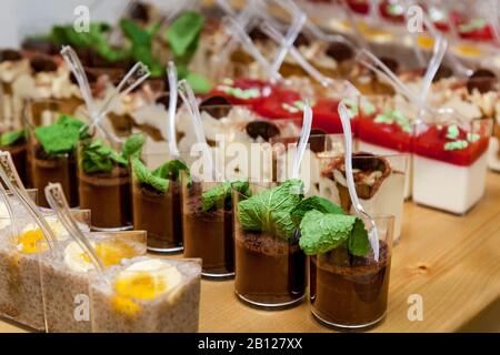 Différents types de desserts tels que la mousse et la gelée ont été décorés de fruits, de noix et de menthe. Banque D'Images