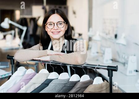 Jeune fille heureuse designer de mode ou assistant de magasin à la recherche de vous Banque D'Images