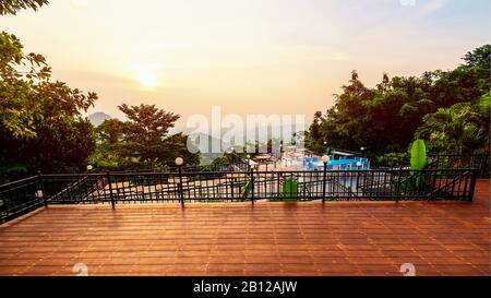 Point de vue à angle élevé pour regarder le magnifique paysage naturel ciel coloré pendant le coucher du soleil. Table et chaises sur la terrasse pour dîner de la res Banque D'Images