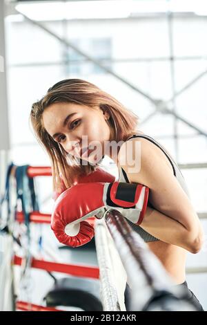 Jolie jeune sportif blond avec des gants de boxe rouge qui vous regardent Banque D'Images