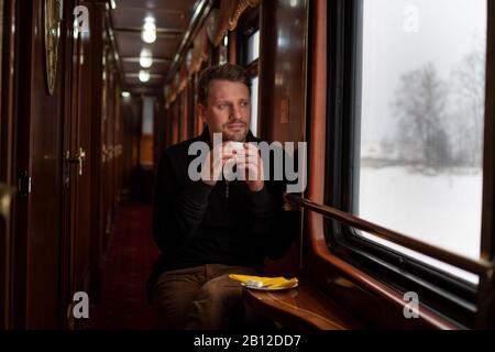 Transsibérien en hiver, l'homme assis dans le train à la fenêtre de la Russie, Banque D'Images