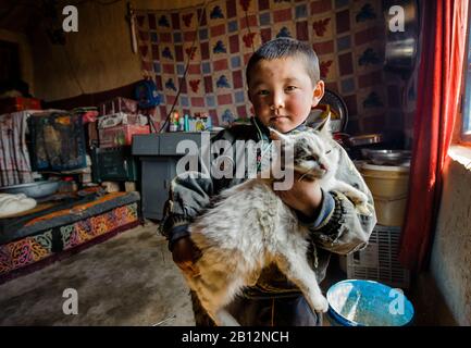 Les enfants du xinjiang éloigné ont très peu de possesions et les animaux de compagnie sont leur principale source de divertissement. Banque D'Images