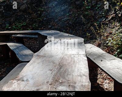 Bancs et tables sculptés à partir d'un support en bois près l'un de l'autre sur le sol près de la pente Banque D'Images