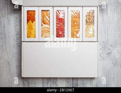 Des boîtes de chips de fruits se trouvent sur un fond en bois blanc Banque D'Images