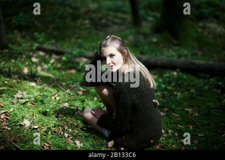 Une fille qui coutait sur le sol de la forêt,portrait Banque D'Images