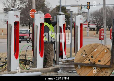 Emporia, Kansas, États-Unis, 22 février 2020 les entrepreneurs en électricité travaillent à l'installation du câblage sur 6 nouvelles stations de suralimentation Tesla situées sur la place commerçante Emporia West. Banque D'Images