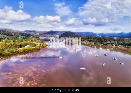 Petit village de pêche aquacole sur la rivière Hawkesbury en Australie près de Sydney - eaux fixes avec marina et fermes d'huîtres. Banque D'Images