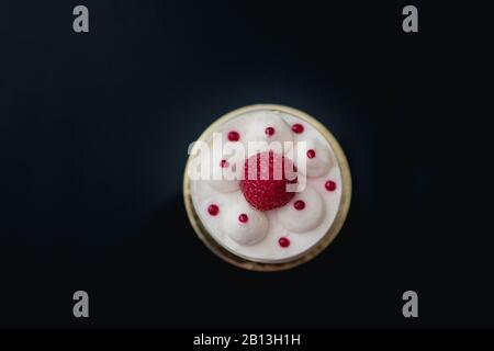 Gâteau au fromage blanc de luxe décoré Gâteau mousse aux framboises fraîches sur un fond sombre. Mise à plat. Close-up. Copier l'espace. Banque D'Images