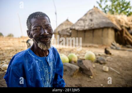 Un homme burkinabe dans son village, en coupant des citrouilles pour les transformer en récipients pour boire et manger, Burkina Faso Banque D'Images