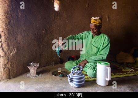 Un homme Fulani prépare du thé, dans un village du Sahel, au Burkina Faso Banque D'Images