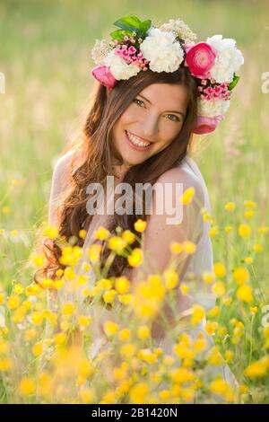 Femme avec couronne de fleurs dans un pré Banque D'Images