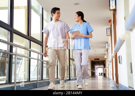 de jeunes thérapeutes asiatiques heureux de marcher parler dans le couloir de la maison de soins infirmiers Banque D'Images