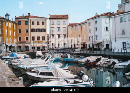 Muggia, Italie - 15 janvier 2015 : le vieux port de Muggia, une ville côtière du nord de l'Italie avec de petits bateaux à moteur amarrés. Banque D'Images