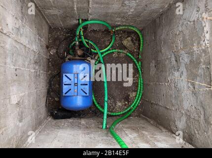 Fosse en béton profond avec station de pompage d'eau pour l'approvisionnement en eau à la maison. Alimentation en eau de la maison. Banque D'Images