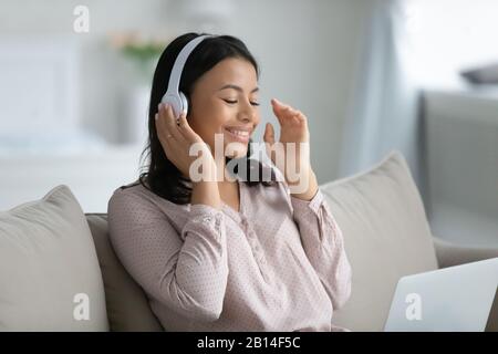 Bonne femme biraciale dans un casque utilisant un ordinateur portable Banque D'Images