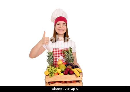 les femmes cuisinent avec les fruits et le pouce vers le haut Banque D'Images