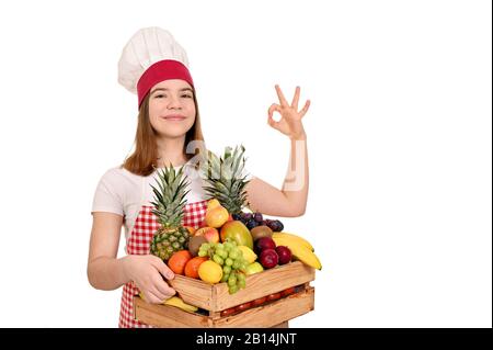 les femmes cuisinent avec des fruits dans une caisse en bois et un signe de main ok Banque D'Images