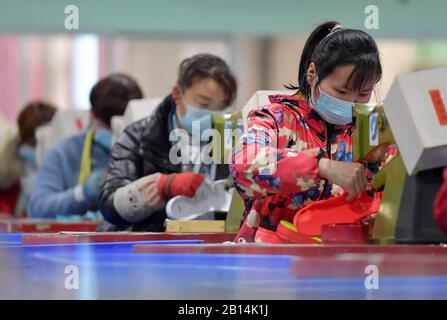 Nanchang, Province Chinoise Du Jiangxi. 22 février 2020. Les travailleurs font des chaussures dans une usine de fabrication de chaussures de la ville de Xiangtang, dans le comté de Nanchang, dans la province du Jiangxi en Chine orientale, le 22 février 2020. De nombreuses entreprises qui comptent sur les exportations ont repris leur production. Crédit: Peng Zhaozhi/Xinhua/Alay Live News Banque D'Images