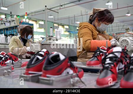 Nanchang, Province Chinoise Du Jiangxi. 22 février 2020. Les travailleurs font des chaussures dans une usine de fabrication de chaussures de la ville de Xiangtang, dans le comté de Nanchang, dans la province du Jiangxi en Chine orientale, le 22 février 2020. De nombreuses entreprises qui comptent sur les exportations ont repris leur production. Crédit: Peng Zhaozhi/Xinhua/Alay Live News Banque D'Images