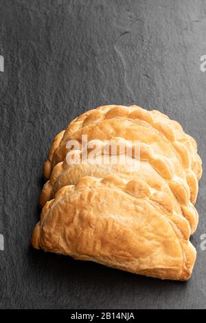 Pâtes feuilletée maison avec garniture de viande hachée sur fond de pierre noire Banque D'Images