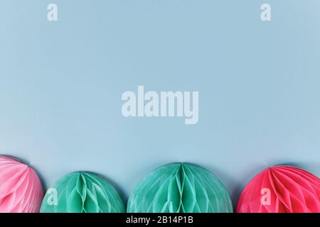 Boules de papier en forme de nid d'abeilles de couleur rose et sarcelle en bas de fond pastel clair bue avec espace de copie vierge Banque D'Images