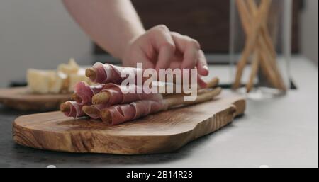 main de l'homme prendre le grissini avec prosciutto de l'olive, photo large Banque D'Images