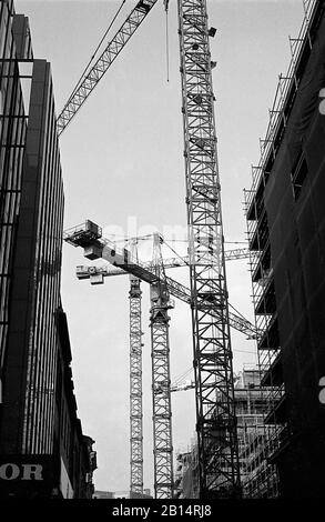 Grues sur les immeubles de grande hauteur, Admiralitätstraße et Ludwig-Erhard-Straße, Hambourg, Allemagne, vers 1988. Photographie de film noir et blanc Banque D'Images