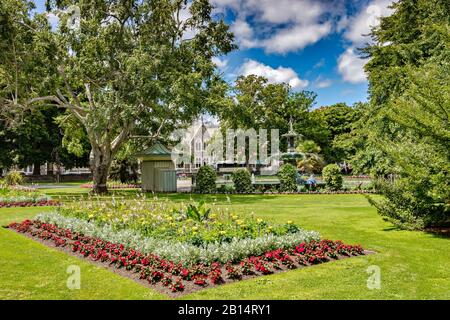 8 janvier 2019: Christchurch, Nouvelle-Zélande - le Gadens botanique, avec un grand lit de fleurs formel, et les bâtiments de la Fontaine de Peacock et du Centre des Arts... Banque D'Images