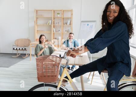 Je plaisante avec une jeune employée afro-américaine assise à vélo. Banque D'Images