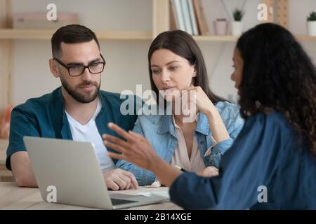Conseiller financier mixte de course montrant la présentation sur ordinateur portable aux clients. Banque D'Images