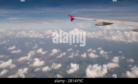 Concept de voyage en avion : vue depuis la fenêtre de l'avion. Nuages et ciel bleu sous aile d'avion comme vu par la fenêtre d'un avion dans un ange large avec cop Banque D'Images