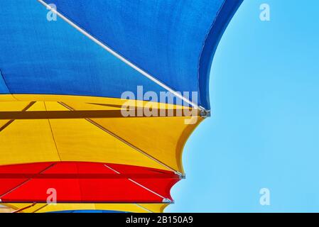 Parasols de plage colorés contre le ciel bleu en été Banque D'Images