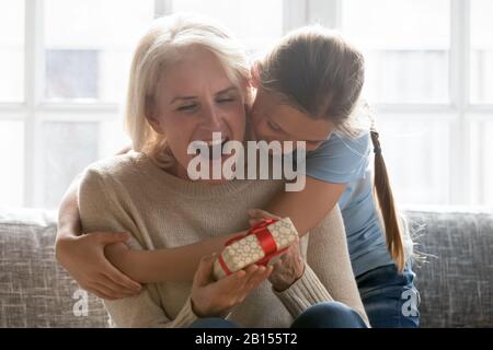 Bonne fille d'école embrassant de arrière-grand-mère excité. Banque D'Images