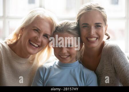 Tête tourné gros plan portrait heureux excité souriant 3 générations de femmes. Banque D'Images