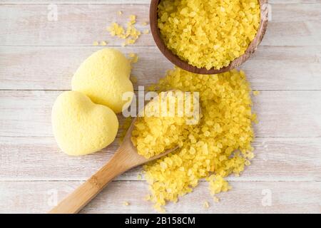 Composition du bain à remous avec bombes de bain dans la forme de coeur, sel de mer, serviettes pour la beauté et le traitement du corps. Relaxation saine, aromathérapie, soins du corps et massage aromatique sur fond en bois. Bain naturel et douche concept cosmétique. Banque D'Images