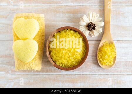 Composition du bain à remous avec bombes de bain dans la forme de coeur, sel de mer, serviettes pour la beauté et le traitement du corps. Relaxation saine, aromathérapie, soins du corps et massage aromatique sur fond en bois. Bain naturel et douche concept cosmétique. Banque D'Images