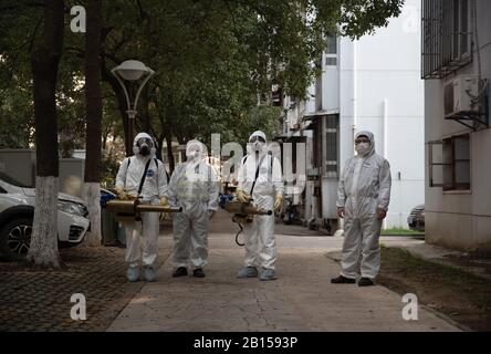 Les volontaires de la communauté chinoise bien protégés posent lorsqu'ils désinfectent un quartier résidentiel pour prévenir le nouveau coronavirus et la pneumonie à Wuhan Banque D'Images