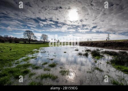 Bury Lancashire, 23 Février 2020. Un moteur à vapeur transporte les passagers le long du chemin de fer East Lancashire à Burrs Country Park alors qu'ils traversent des champs inondés après une forte pluie d'une nuit. Le ciel bleu a accueilli les visiteurs pendant une courte pause dans le temps dimanche matin avant la prochaine tempête est due à arriver pendant la nuit dans le nord-ouest de l'Angleterre. Crédit: Paul Heyes/Alay Live News Banque D'Images