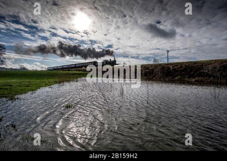 Bury Lancashire, 23 Février 2020. Un moteur à vapeur transporte les passagers le long du chemin de fer East Lancashire à Burrs Country Park alors qu'ils traversent des champs inondés après une forte pluie d'une nuit. Le ciel bleu a accueilli les visiteurs pendant une courte pause dans le temps dimanche matin avant la prochaine tempête est due à arriver pendant la nuit dans le nord-ouest de l'Angleterre. Crédit: Paul Heyes/Alay Live News Banque D'Images