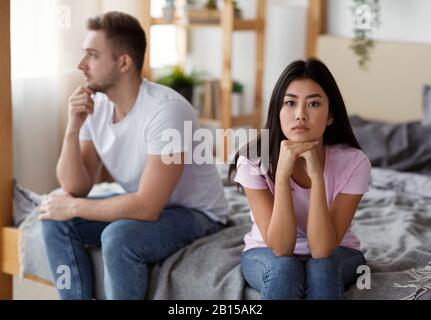 Une Femme Asiatique Triste Assise Avec Un Mari Non Aimé Sur Un Lit Intérieur Banque D'Images