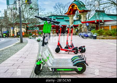 Berlin, Allemagne - 21 février 2020 : scooters électriques à louer sur le trottoir devant la porte à éléphant du zoo de Berlin. Banque D'Images