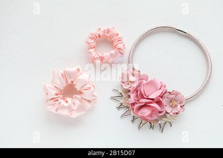 Accessoires pour cheveux roses avec roses. Soie Rose Scotchy isolé sur fond blanc. Outils et accessoires de Coiffure plats comme les Scrocrunchies de cheveux de couleur Banque D'Images