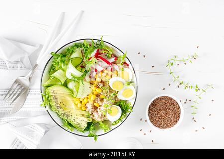 Petit déjeuner gruau porridge avec salade de légumes frais de concombre, de radis, de laitue, de maïs, d'avocat, de graines de chia et d'œufs durs. Alimentation saine et équilibrée. Banque D'Images