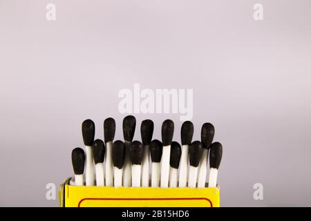 Un concept créatif d'une boîte de correspondance de cire avec bâton et tête noire Banque D'Images